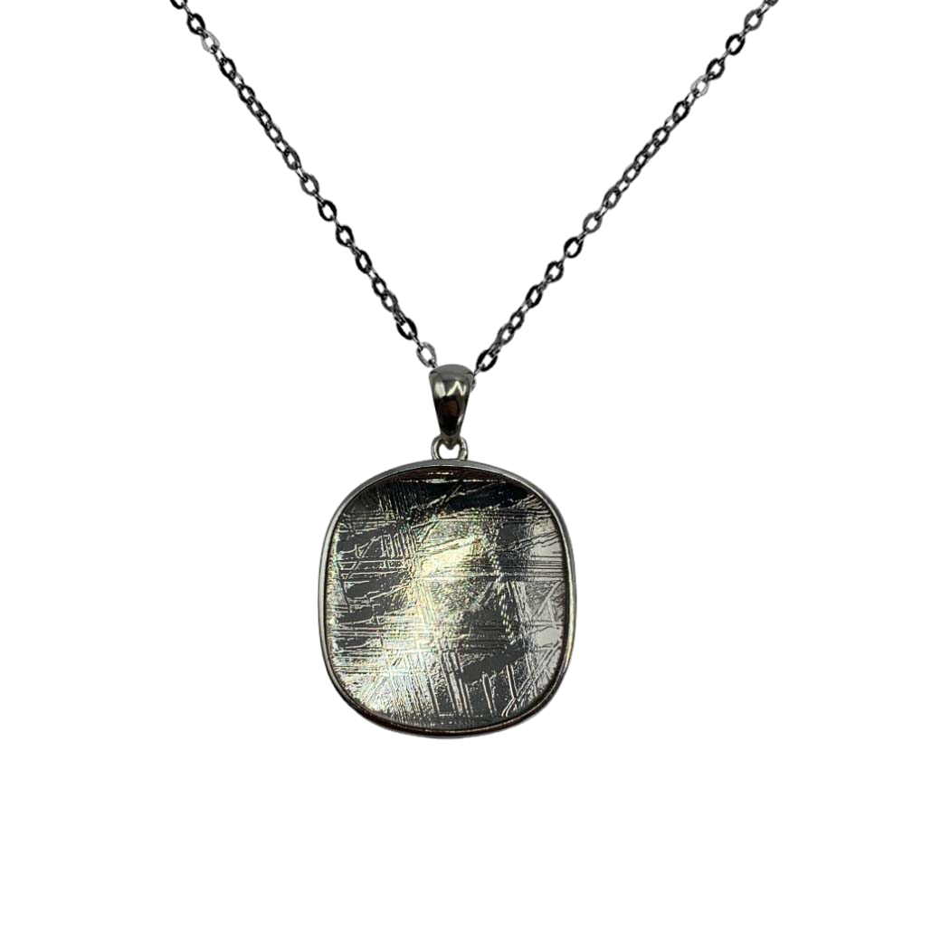 Semi-circular Muonionalusta meteorite plate pendant with beveled silver.