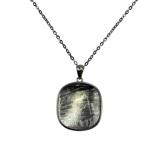 Semi-circular Muonionalusta meteorite plate pendant with beveled silver.